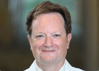 Dr John H Powers smiling.